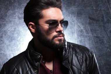 güneş gözlüklü, uzun sakallı genç bir adam yan görünüm