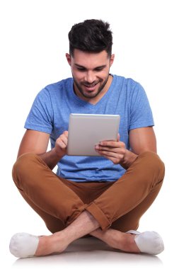 onun tablet üzerinde çalışan mutlu casual adam oturmuş