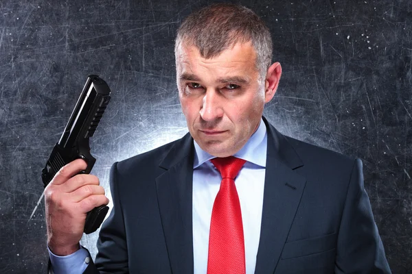 Dramatic picture of an old assassin holding his gun — Stock Photo, Image
