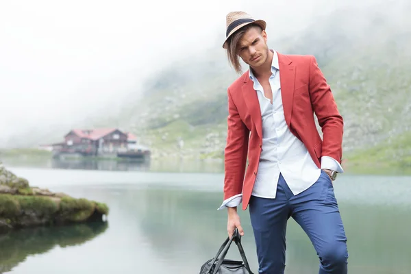 Modelo masculino de moda posando frente a un lago —  Fotos de Stock