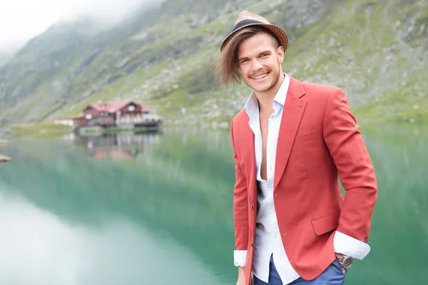 Skrattar ung man står nära en sjö — Stockfoto