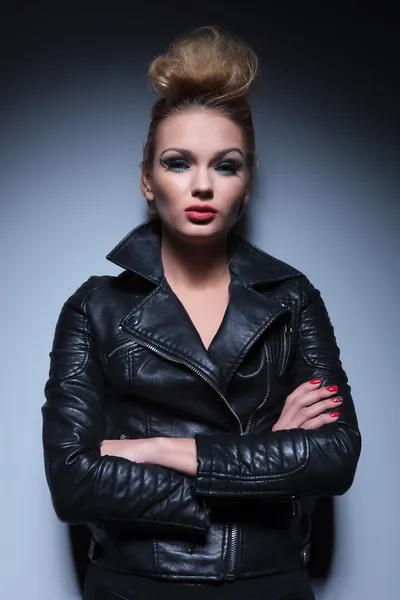 Woman in leather jacket standing with arms crossed — Stock Photo, Image