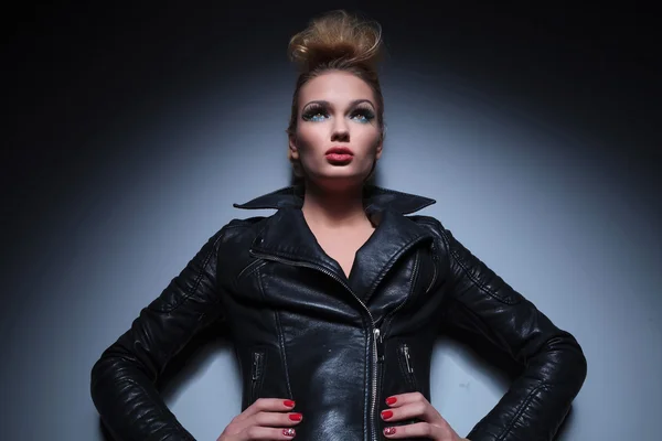 Woman in leather jacket standing with hands on hips and looking — Stock Photo, Image