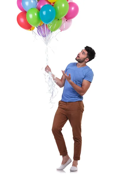 Uomo casual che presenta un mucchio di palloncini — Foto Stock