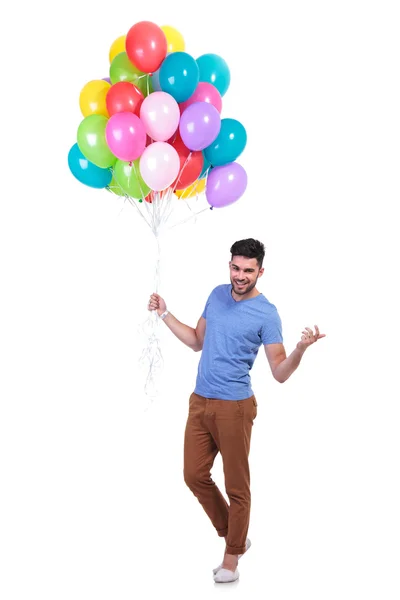 Человек с кучей шариков приглашает на вечеринку — стоковое фото