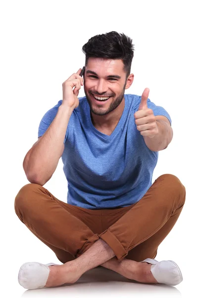 Sentado hombre hablando por teléfono y haciendo ok — Foto de Stock