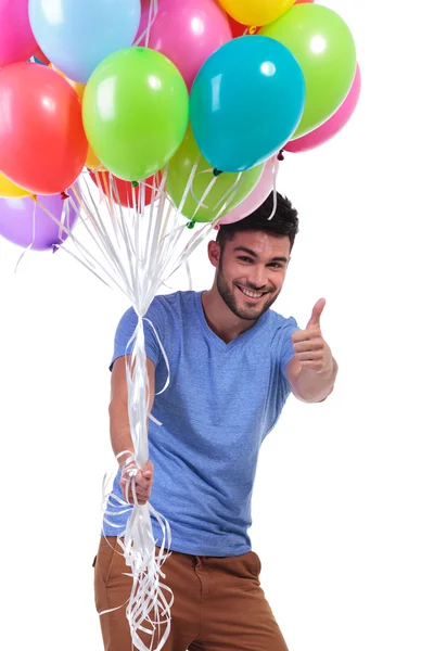 Man holding a bunch of balloons and making ok — Stock Photo, Image