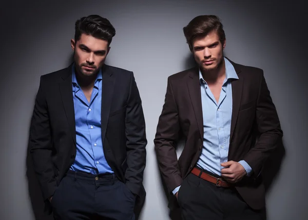 Serious male models posing against gray wall — Stock Photo, Image