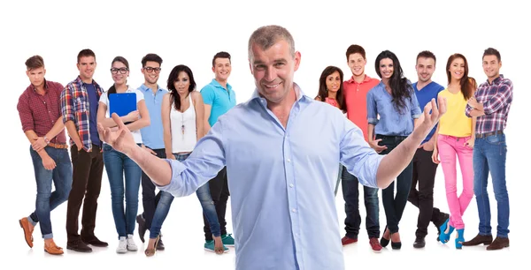 Mature casual man welcoming to his young team — Stock Photo, Image