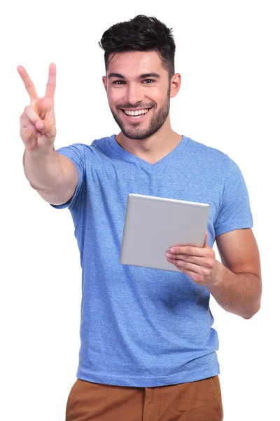 Man reading on tablet pad and making the victory sign — Stock Photo, Image