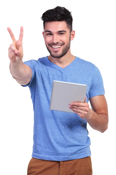 Hombre leyendo en tableta y haciendo la señal de victoria —  Fotos de Stock