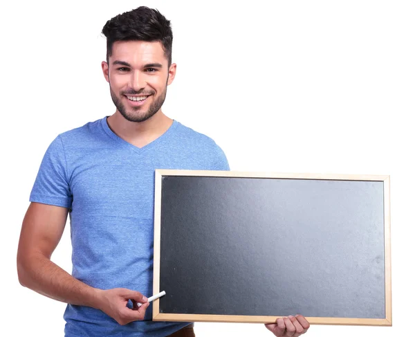 Estudante casual apresentando um quadro negro em branco — Fotografia de Stock