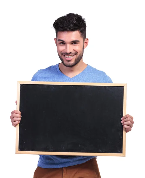 Happy casual man showing a blank board — Stock Photo, Image