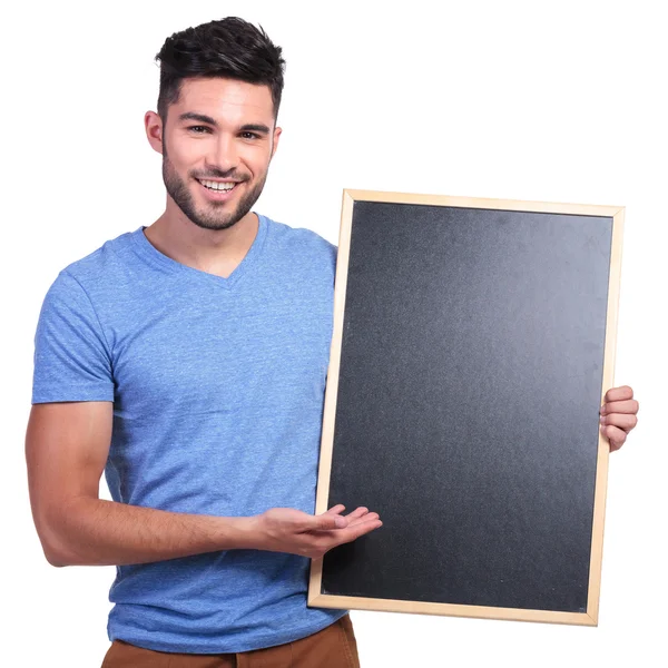 Joven sonriente presentando una pizarra — Foto de Stock