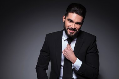 Genç Moda adam gülümsüyor ve kravat ayarlar
