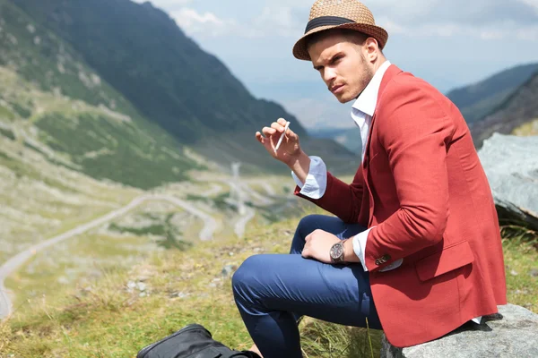 Jovem homem de moda com cigarro ao ar livre — Fotografia de Stock