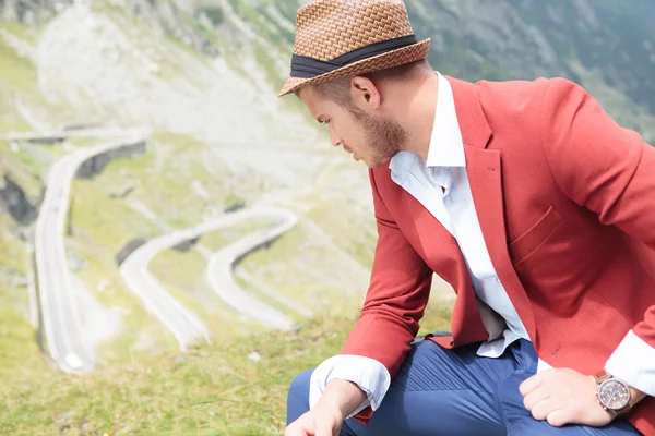 Outdoor fashion man sits and looks down — Stock Photo, Image