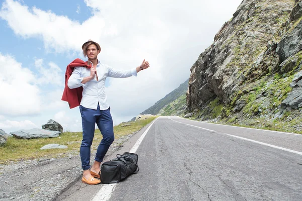 Ungt mode man hitchhikes med glädje — Stockfoto