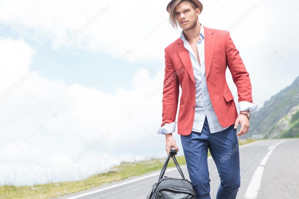 young fashion man carries bag outdoor