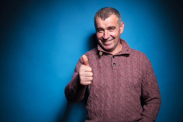 старший случайный мужчина показывает большой палец вверх
