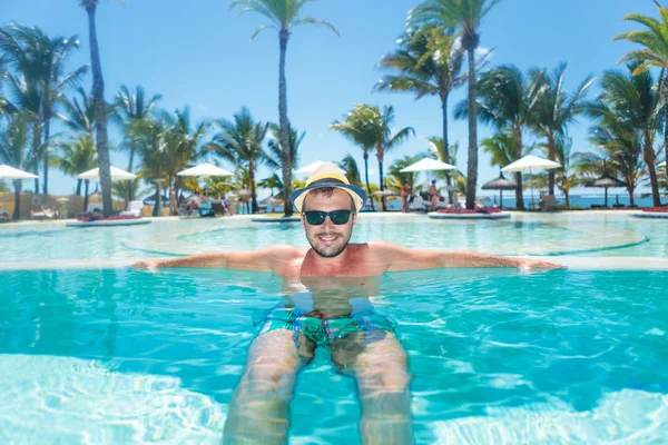 Happy man relaxing in an infinity pool — Stock Photo, Image