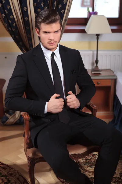 Young business man sits on chair — Stock Photo, Image