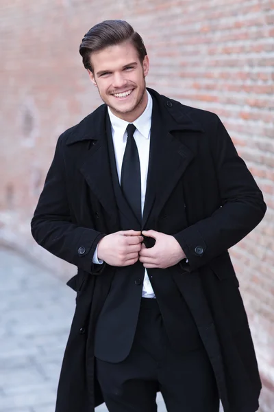 Young business man buttons his jacket — Stock Photo, Image