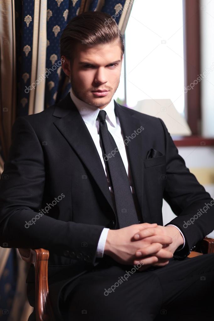 business man looks at you from chair