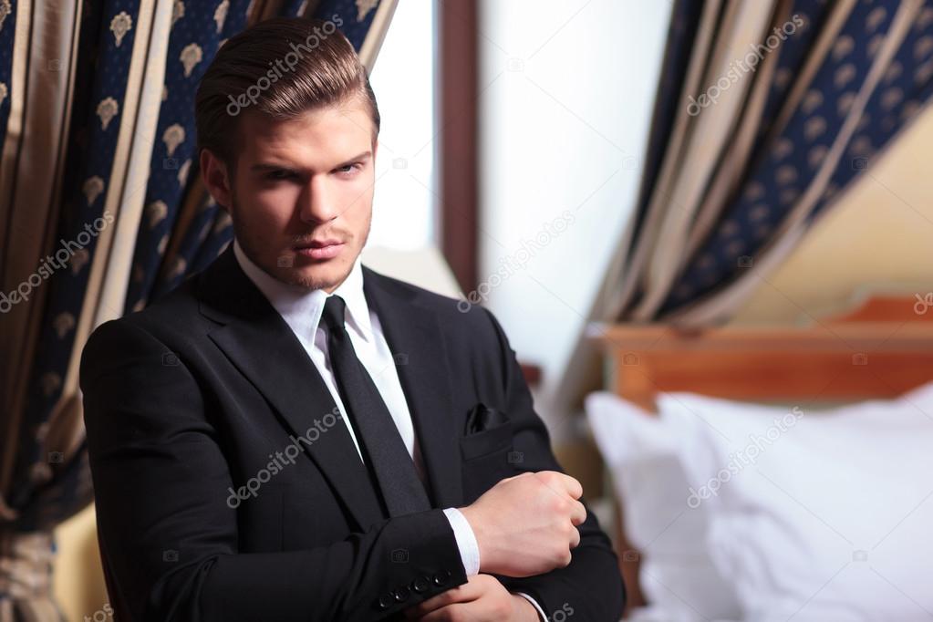 young business man fixes his cuffs
