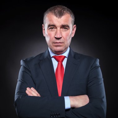 katlanmış elleriyle ciddi olgun iş adamı