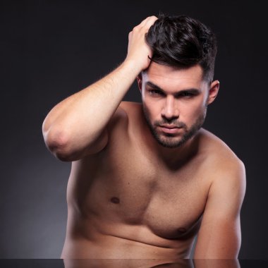 çıplak genç adam saçlarını düzeltir