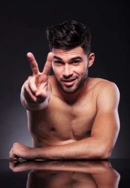 çıplak genç adam zafer gösterir