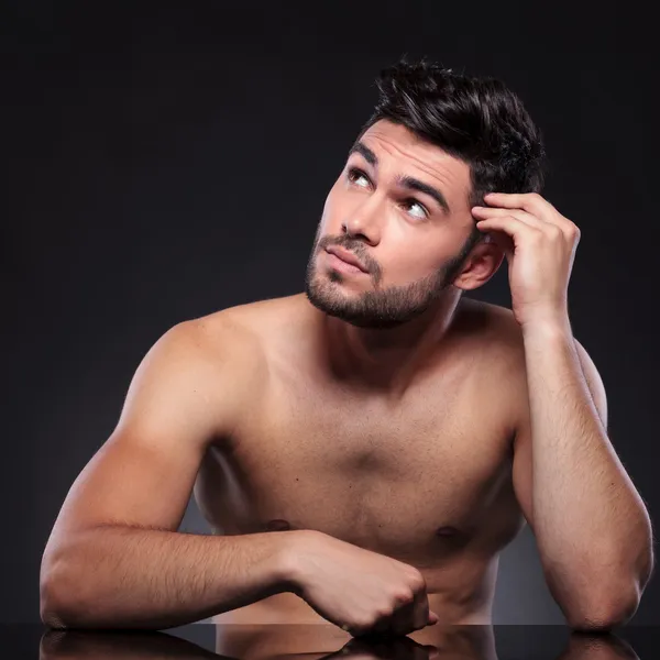 Naked young man looks up — Stock Photo, Image