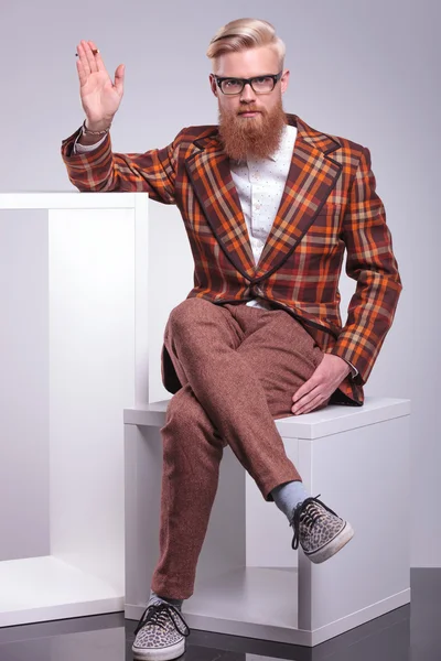 Модный бородатый мужчина курит сигарету и машет рукой — стоковое фото
