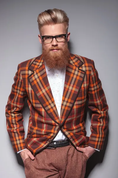 Modelo de moda sonriente con barba larga apoyada en la pared gris — Foto de Stock