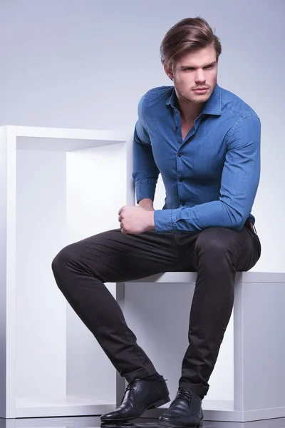 Serious fashion man sitting and looks away — Stock Photo, Image