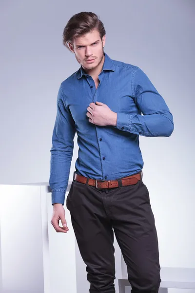 Fashion man is unbuttoning his shirt with one hand — Stock Photo, Image