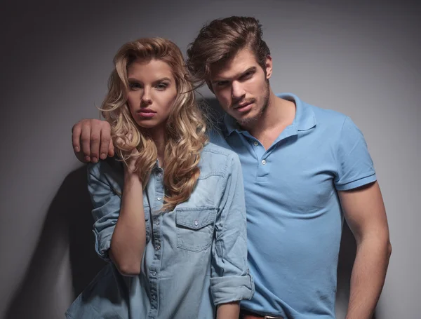 Portrait of a young fashion couple standing embraced — Stock Photo, Image