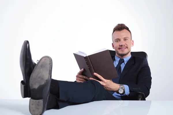 Hombre de negocios sonríe con libro abierto —  Fotos de Stock