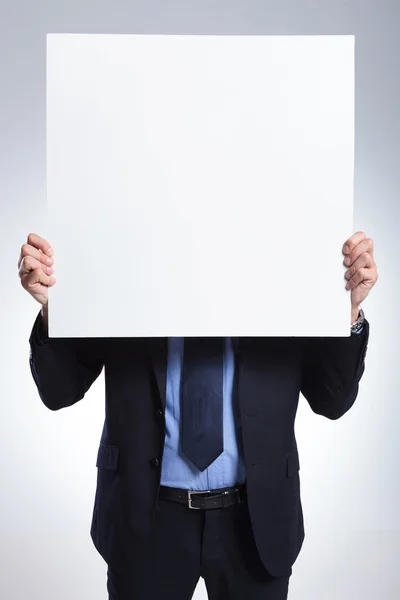 Homem de negócios se esconde atrás do painel — Fotografia de Stock