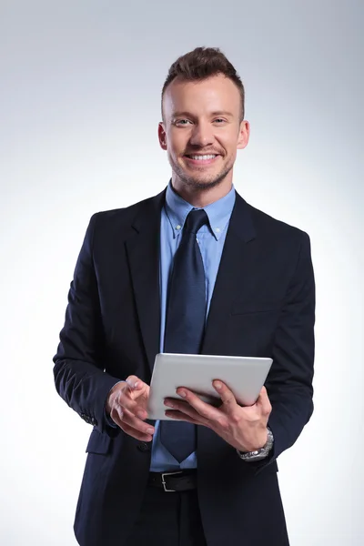 Business man with tablet smiles at you — Stock Photo, Image