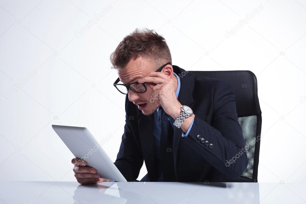 business man looks at his tablet with awe