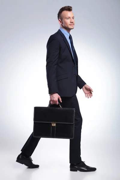 Obchodní muž chodí s kufrem v ruce — Stock fotografie