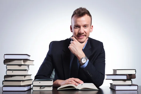 Pensive business man among books — Stock Photo, Image