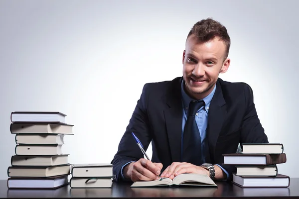 Business man writes and smiles — Stock Photo, Image