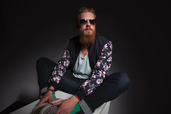 Бородатый человек сидит с ногами вместе — стоковое фото