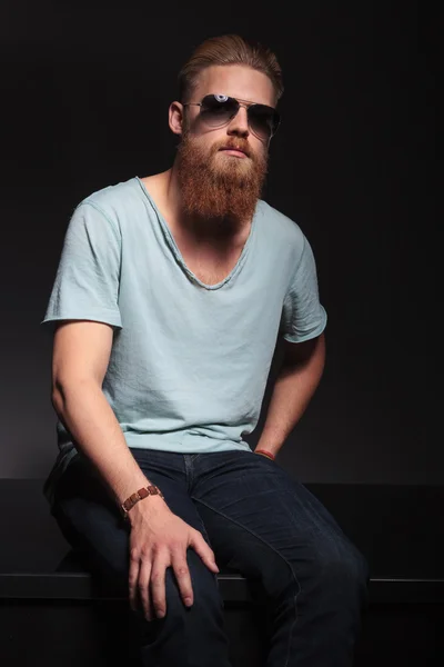 Bearded man sits and looks at you — Stock Photo, Image