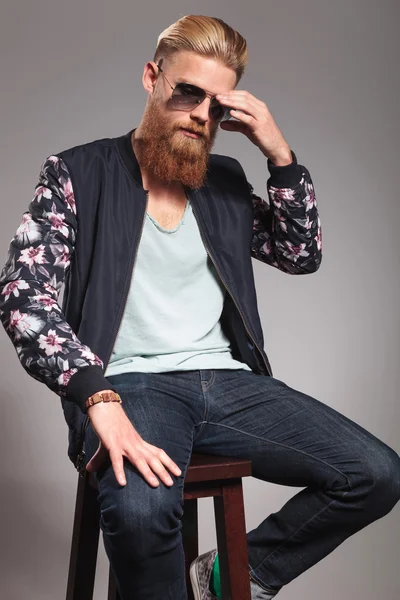 Bearded young man adjusts sunglasses — Stock Photo, Image