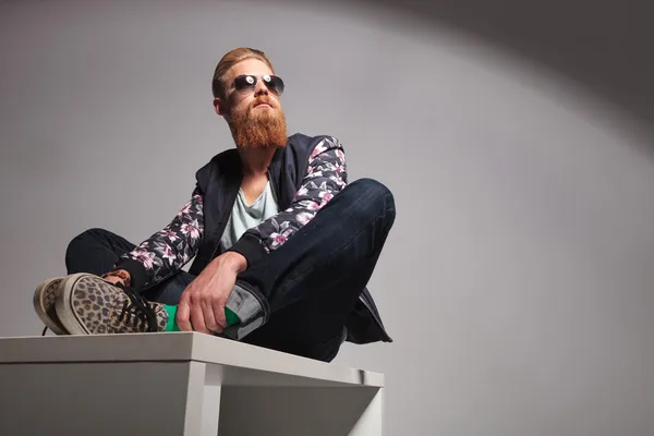 Seated bearded young man looks away — Stock Photo, Image