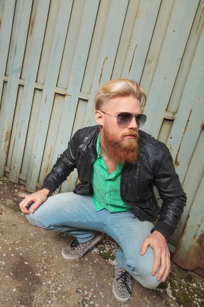 Young bearded man squatting outdoor — Stock Photo, Image